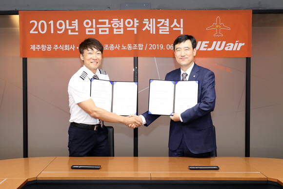 박준 제주항공조종사노조 위원장(사진 왼쪽)과 이석주 제주항공 대표이사가 2019년 임금협약을 체결하고 악수하고 있다. ⓒ 제주항공