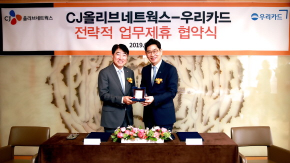 18일 진행된 우리카드와 CJ올리브네트웍스 업무제휴 협약식에서 정원재 우리카드 사장(오른쪽)이 이경배 CJ올리브네트웍스 대표이사에게 감사카드를 전달하며 기념촬영을 하고 있다. ⓒ 우리카드