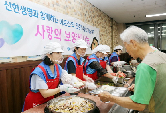 신한생명이 20일 노인복지관에서 홀로 생활하고 계신 독거 어르신의 건강한 여름나기 지원을 위한 보양식 나눔 봉사활동을 진행했다. 사진은 서울 양천어르신종합복지관에서 직원봉사자가 어르신에게 보양식 배식을 하고 있는 모습. ⓒ 신한생명