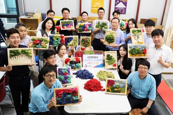 CJ대한통운 임직원들이 스칸디아모스 공기정화액자를 완성하고 기념사진 촬영을 하고 있다. ⓒ CJ대한통운