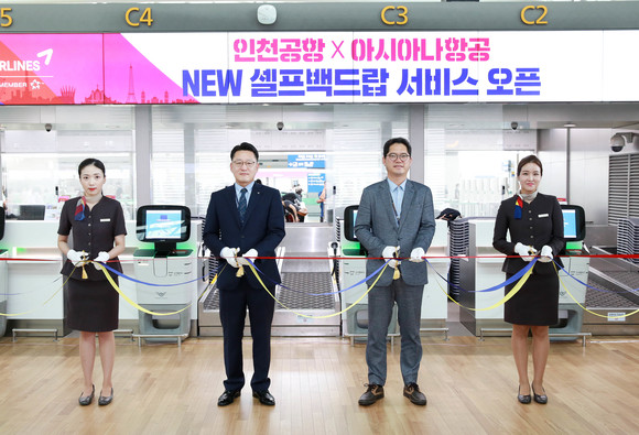 아시아나항공 자동수하물 위탁서비스 존 오픈 기념행사에서 아시아나항공 박수상 인천국제공항서비스2팀장(왼쪽 두번째)을 비롯한 공항서비스 직원과 인천국제공항공사 스마트추진실 안정준 실장(왼쪽 세번째)이 테이프 컷팅식을 진행하고 있다. ⓒ 아시아나항공
