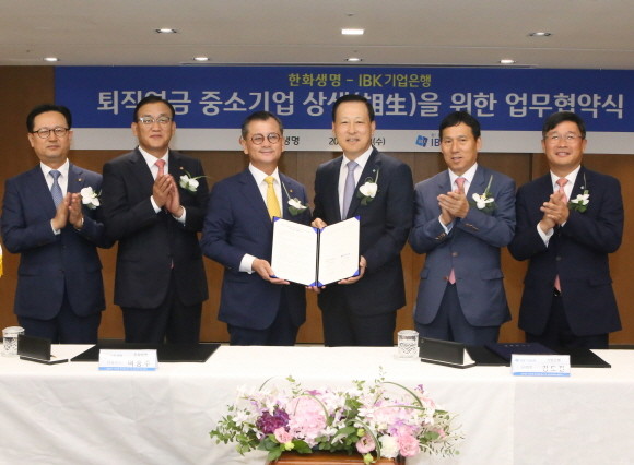 한화생명(대표 차남규·여승주)과 IBK기업은행이 28일 오전 10시 IBK기업은행 을지로 본점에서 '퇴직연금 중소기업 상생을 위한 업무협약'을 체결했다. 협약식에 참석한 여승주 한화생명 대표이사 사장(왼쪽에서 세 번째), 김도진 IBK기업은행 행장(왼쪽에서 네 번째)을 비롯한 임직원들이 협약식 후 기념촬영을 하고 있는 모습. ⓒ한화생명