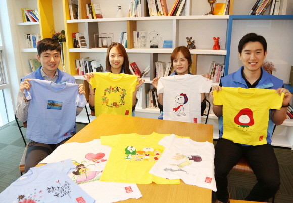 신한생명은 지난 한 달간 해외 기후난민 어린이를 돕기 위한 '희망T 캠페인'을 실시했다. 캠페인에 참여한 직원들이 제작한 희망티셔츠를 들고 기념촬영을 하고 있다. ⓒ 신한생명