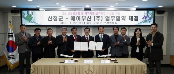 한태근 에어부산 사장(왼쪽 7번째)과 이재근 산청 군수(왼쪽 6번째)를 비롯한 관계자들이 업무 협약을 체결 후 기념촬영을 하고 있다. ⓒ 에어부산