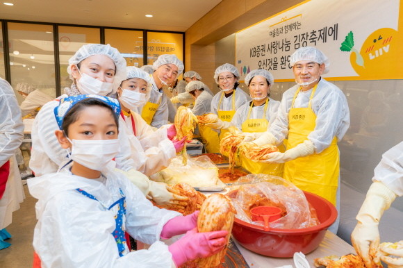 KB증권이 지난 7일 서울 여의도 본사에서 '사랑나눔 김장축제' 행사를 진행했다. 김성현 사장(오른쪽 첫 번째)와 박정림 사장(오른쪽 두 번째)가 임직원 가족 및 다문화 가족들과 기념사진을 촬영하고 있는 모습. ⓒ KB증권