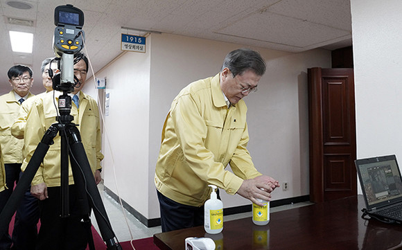 문 대통령이 신종 코로나 바이러스 감염증 대응 종합점검회의 참석 전 세정제를 이용해 손을 닦고 있다. ⓒ 청와대