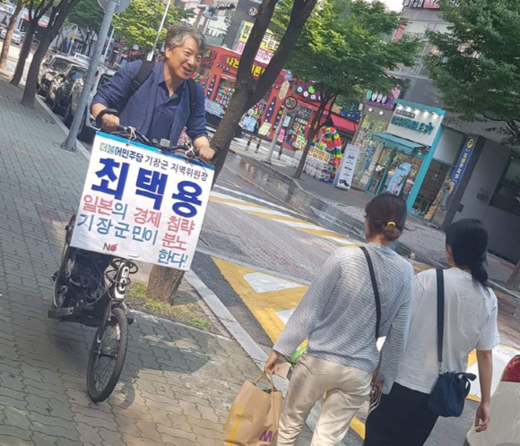 지난해 더불어민주당 부산기장지역위원장 시절에 고가 논란에 오른 '문제의 자전거'를 타고 No japan 캠페인을 펼치고 있다. ⓒ 최택용 선거사무소