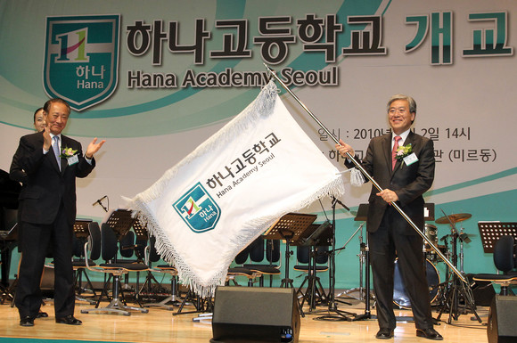 지난 2010년 3월2일 서울 은평구 진관동 하나고등학교에서 열린 개교식 및 입학식에서 김승유 하나금융그룹회장 겸 하나고 이사장이 김진성 교장에게 교기를 전달, 김 교장이 교기를 흔들고 있다. 하나고는 자립형 사립고로 설립됐으며, 당시 204명이 입학했다. ⓒ 연합뉴스