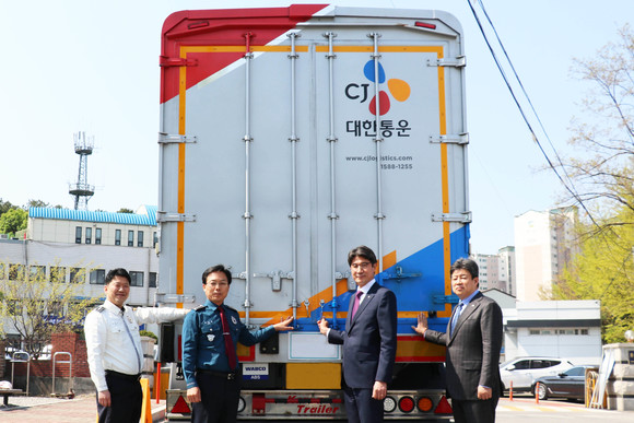 한광섭 CJ대한통운 부사장(가운데 오른쪽), 정태영 CJ대한통운 부사장(오른쪽 첫번째), 권기섭 광주경찰서 경찰서장(가운데 왼쪽), 고민식 광주경찰서 경비교통과장(왼쪽 첫번째)이 함께 형광 반사띠를 부착하며 기념사진촬영을 하고 있다. ⓒ CJ대한통운