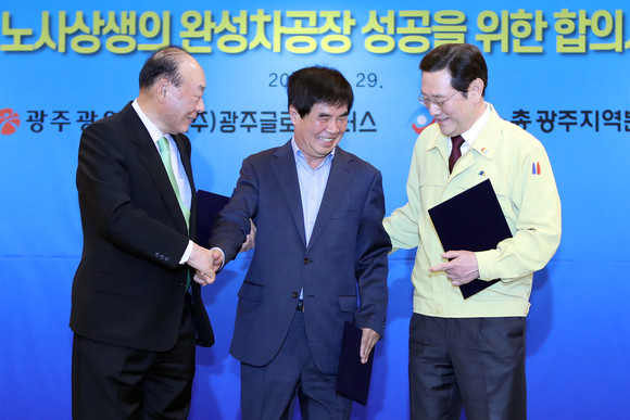 이용섭 광주시장(오른쪽부터), 윤종해 한국노총 광주지역본부 의장, 박광태 광주글로벌모터스(GGM) 대표이사가 29일 광주시청 비즈니스룸에서 노동계의 광주형 일자리 복귀를 선언한 뒤 기념촬영을 준비하면서 중앙 자리를 서로 양보하고 있다. ⓒ 연합뉴스