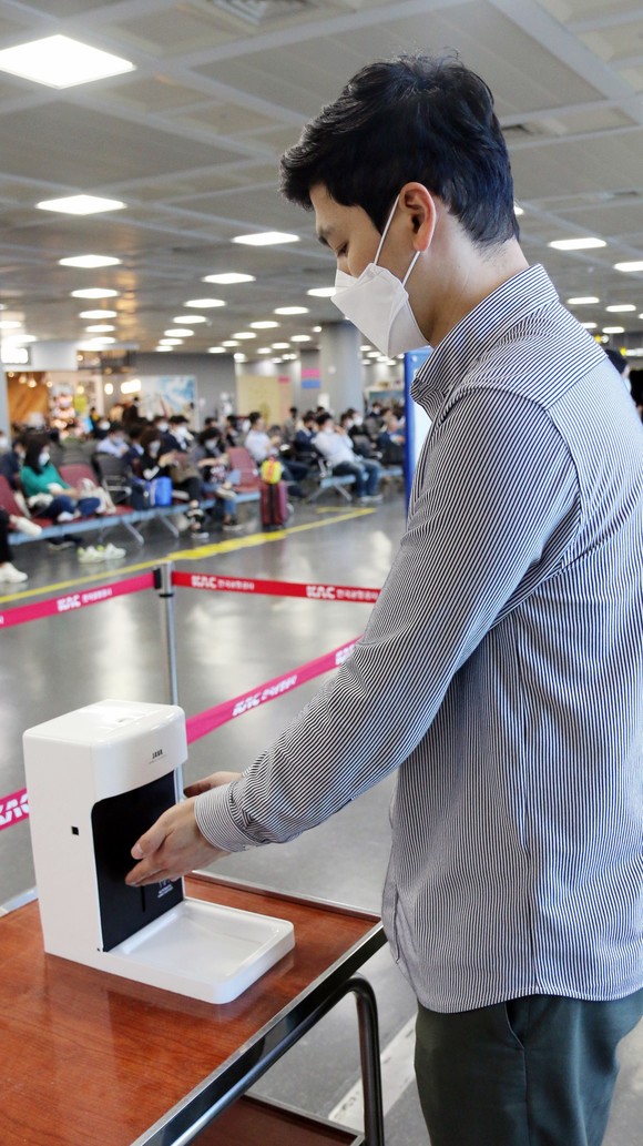 에어부산 승객이 탑승 전 탑승구 앞에 비치된 자동 손 소독기로 손 소독을 하고 있다. ⓒ 에어부산