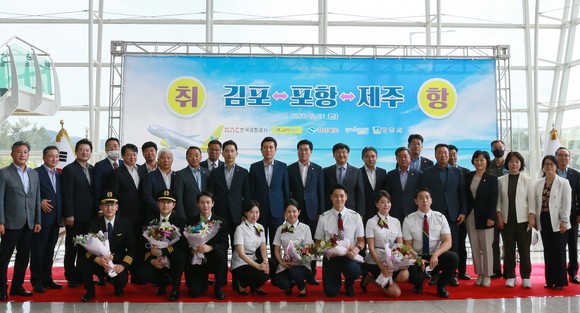 포항공항 1층에서 열린 김포~포항, 포항~제주 노선 첫 운항을 알리는 취항식에서 기념사진을 촬영하고 있는 모습. ⓒ 진에어