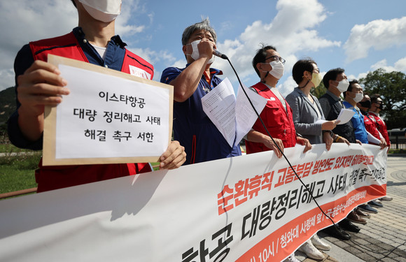 이스타항공 대량 정리해고 통보 규탄 기자회견에서 민주노총 전국공공운수노동조합 관계자가 손팻말을 들고 있다. ⓒ 연합뉴스