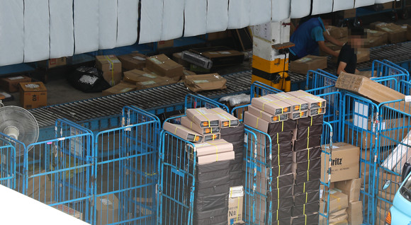 지난 17일 오후 서울 시내의 한 택배 물류센터에서 관계자들이 물품을 분류하고 있는 모습. ⓒ 연합뉴스