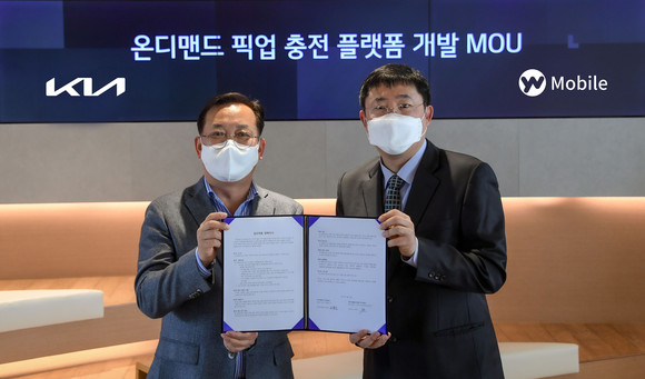 왼쪽부터 오용진 기아 판촉전략실장(상무), 이영석 YW모바일 대표이사가 기념촬영을 하는 모습. ⓒ 기아