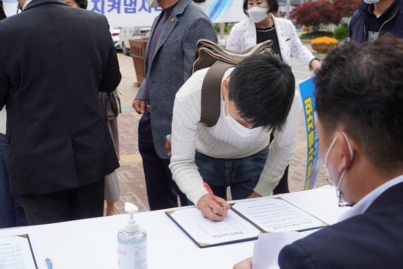 평택역을 지나는 평택시민들이 정부의 지원을 촉구하기 위해 서명하고 있는 모습. ⓒ 쌍용자동차