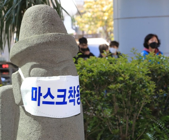 제주국제공항 입구에 세워진 돌하르방에 마스크가 씌어 있다. ⓒ 연합뉴스