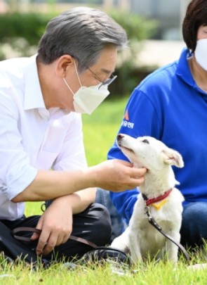 더불어민주당 대선 경선 후보인 이재명 경기도지사가 20일 경기도 고양시 덕양구 농업기술센터 내 잔디밭에서 열린 동물복지 공약 발표 기자간담회에서 동물보호센터 보호견 '오리'와 시간을 보내고 있다. ⓒ 국회사진기자단