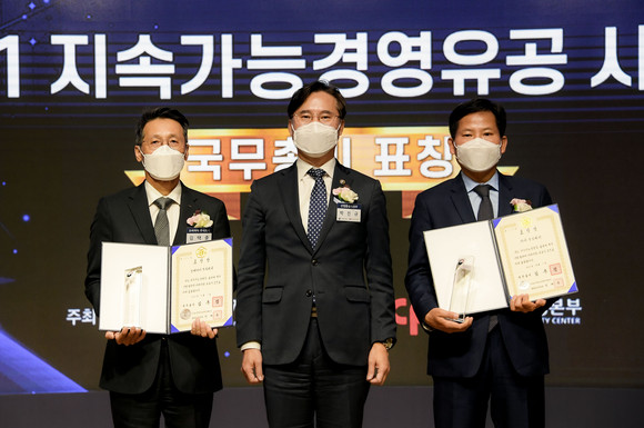 김상대 기아 기업전략실장(전무, 오른쪽)이 2021 지속가능경영유공 정부포상 국무총리 표창을 수상하고, 박진규 산업통상자원부 차관(가운데)과 기념촬영하고 있다. ⓒ 기아