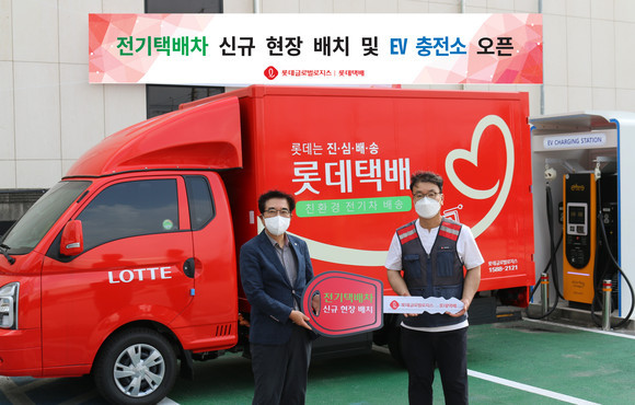 안대준 롯데글로벌로지스 택배사업본부장(왼쪽)이 올해 7월 경기 남양주 서울북부지점에서 택배기사에게 전기택배차를 인도하고 있다. ⓒ 롯데글로벌로지스