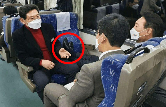 윤 후보가 열차의 비어있는 좌석에 구두를 신은채 발을 올리고, 보좌진들의 대화를 듣고 있다. ⓒ 연합뉴스