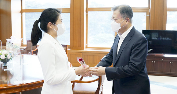 세계여성의 날을 맞아 문재인 대통령이 김현지 간호장교에게 장미꽃을 전달하고 있다. ⓒ 청와대