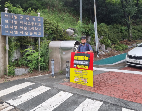 범부산시민단체가 지난 24일 부산 금정구 구서동 브니엘고교 정문 앞에서 주일예배를 보러 오는 온천 A 교인들을 상대로 피켓을 들고 1인 시위를 하고 있다. Ⓒ 부산바로세우기연대