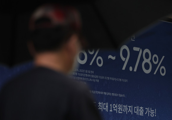 금융부채를 진 38만여 가구는 현재 소득의 40% 이상을 힘겹게 원리금 상환에 쏟아붓고 있는 것으로 나타났다. 사진은 시중 은행에 붙어 있는 대출 관련 홍보물. ⓒ 연합뉴스
