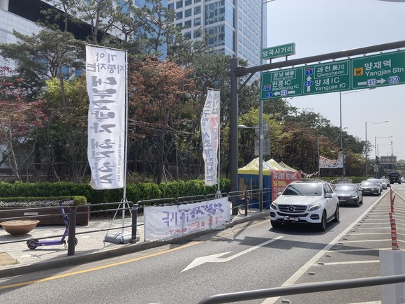 깃발형 현수막은 천막과 함께 도로를 이용하는 운전자, 보행자들의 시야를 가려 교통사고 위험성마저 높이고 있다. ⓒ 독자제공
