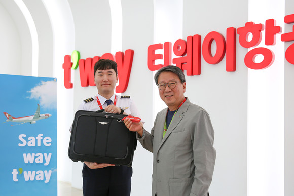 정홍근 티웨이항공 대표가 운항 승무원에게 슬로건 키링을 전달하며 기념촬영을 하고 있다. ⓒ 티웨이항공