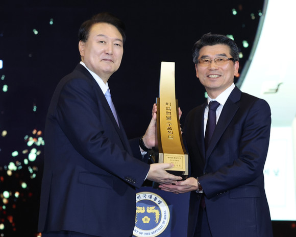 윤석열 대통령이 제60회 무역의날 기념식에서 송호성 기아 대표이사에게 200억불 수출의 탑을 친수한 뒤 기념촬영을 하고 있다. ⓒ 연합뉴스