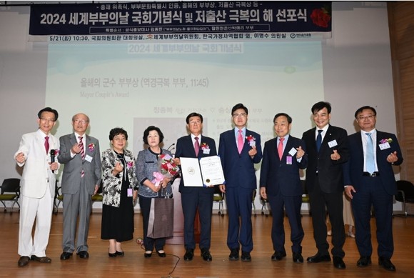 정종복 기장군수(왼쪽 다섯 번째)가 부인 송삼선 여사(왼쪽 네 번째)와 21일 2024 세계 부부의 날 국회기념식에서 전국 시장 군수 구청장 부문 '올해의 군수 부부상'을 수상한 가운데 관계자들과 기념촬영을 하고 있다. Ⓒ기장군