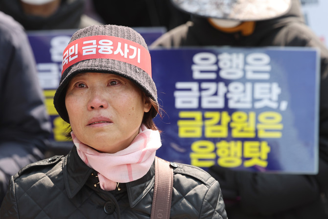 지난 3월15일 서울 중구 NH농협은행 앞에서 열린 '대국민 금융 사기 규탄 집회'에 참석한 홍콩H지수 기초 주가연계증권(ELS) 피해자 모임 관계자의 눈에 눈물이 맺혀 있다. ⓒ 연합뉴스