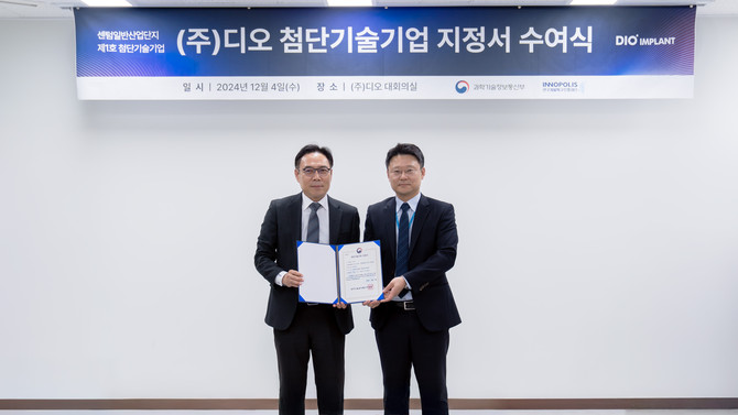 지난 4일 디오 부산 사옥 대회의실에서 정희주 연구개발특구진행재단 실장(오른쪽)이 김종원 디오 대표이사(왼쪽)에게 첨단기술기업 지정서를 전달하고 기념촬영을 하고 있다. ⓒ 디오