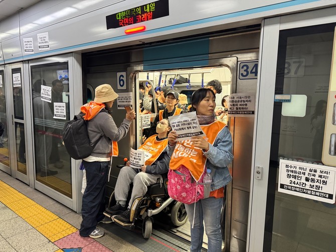 열차 출발을 막는 전장연 시위 참가자들. = 김우람 기자