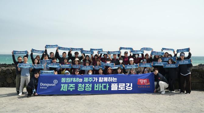 지난 18일 서귀포시 표선면에서 진행된 '제주 청정 바다 플로깅' 행사에서 동원F&B 직원들이 기념 사진 촬영을 하고 있다. ⓒ 동원F&B