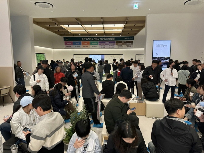 '동탄 포레파크 자연& 푸르지오' 모형도 관람 및 상담석에서 대기하는 방문객들의 모습. © 대우건설