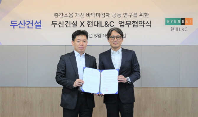 16일 두산건설은 종합 건자재 기업 현대L&C와 '층간소음 개선을 위한 바닥 마감재 공동 연구 업무협약(MOU)'을 체결했다고 밝혔다. 신홍철 두산건설 상무(왼쪽), 성재용 현대L&C 상무. © 두산건설