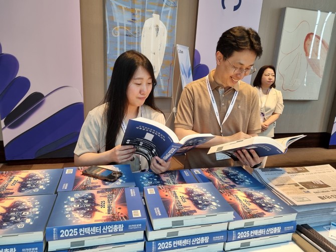 제24회 대한민국 채널&커뮤니케이션(KCCM) 컨퍼런스 현장에서 '2025 컨택센터 산업총람'을 수령하는 참석자들 = 김상준 기자
