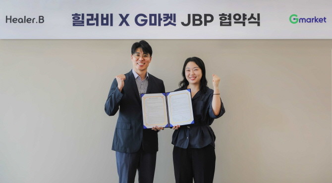 서울 강남구 G마켓 본사에서 열린 업무 협약식에서 조성훈 힐러비 브랜드커머스 그룹장(왼쪽)과 유보연 지마켓 뷰티 팀장(오른쪽)이 기념 촬영을 하고 있다. © 코웨이