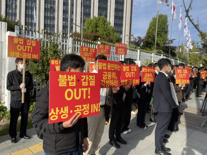 한국감정평가사협회 회원들이 24일 오전 서울 종로구 세종대로 금융위원회 앞에서 KB국민은행의 불법 감정평가 행위 중단을 촉구하며 피켓을 들고 있다. = 박선린 기자
