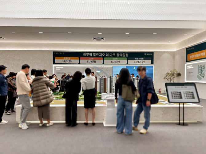 모형도 앞에서 도시의 변화 방향을 꼼꼼히 살피는 관람객들. = 김주환 기자