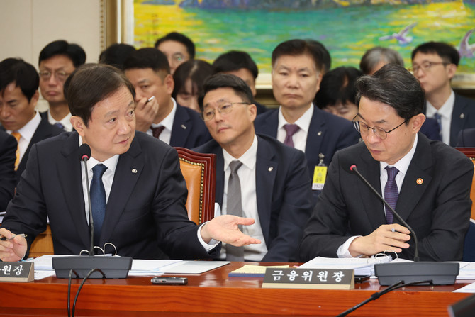 이억원 금융위원장과 이찬진 금융감독원장(왼쪽)이 27일 국회 정무위원회의 종합 국정감사에서 대화하고 있다. ⓒ 연합사진