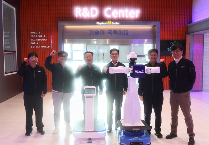 김동헌 대표이사(우측 세 번째)와 노경식 연구소장(우측 두 번째)이 피지컬 AI R&D 센터 연구원들과 개발 중인 모바일 휴머노이드 및 AMR 로봇을 선보이며 오픈 기념 촬영을 하고 있다. ⓒ 유일로보틱스