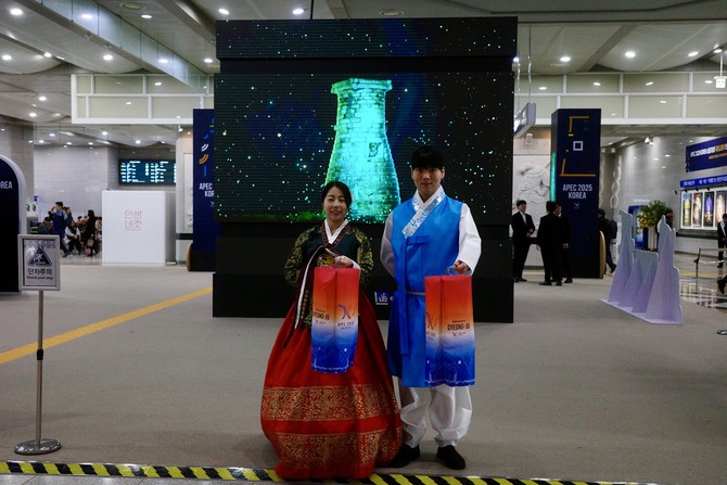 한복 차림의 안내 요원과 자원봉사자들이 방문객을 반갑게 맞이하며 기념 촬영을 돕고 있다. = 김주환 기자