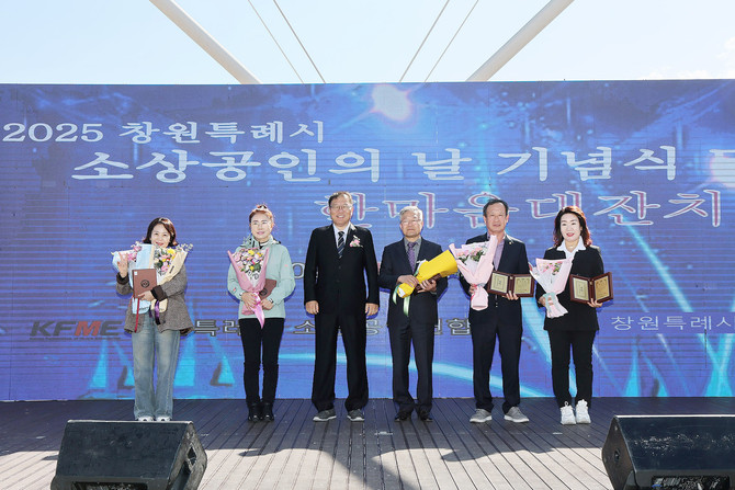 창원시가 마산합포구 합포수변공원에서 국화 향기가 가득한 가을 정취 속에 '2025년 소상공인의 날 기념식 및 한마음대잔치'를 개최하고 기념촬영을 하고 있다. ⓒ 창원시