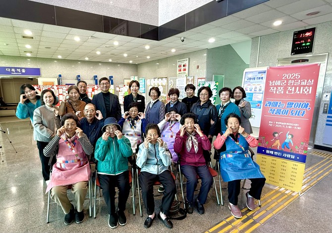 남해군이 평생학습관 1층 로비에서 '2025년 남해군 문해교실 작품전시회' 개최식을 갖고 기념촬영을 하고 있다. ⓒ 남해군