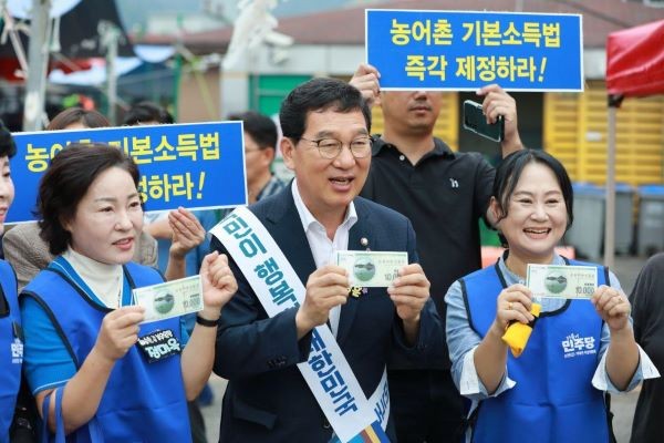 2025년 추석 연휴 첫날, 순천 아랫장을 찾은 신정훈 의원이 시민들과 함께 지역사랑상품권을 들고 기념촬영을 하고 있다. ⓒ 신정훈 의원