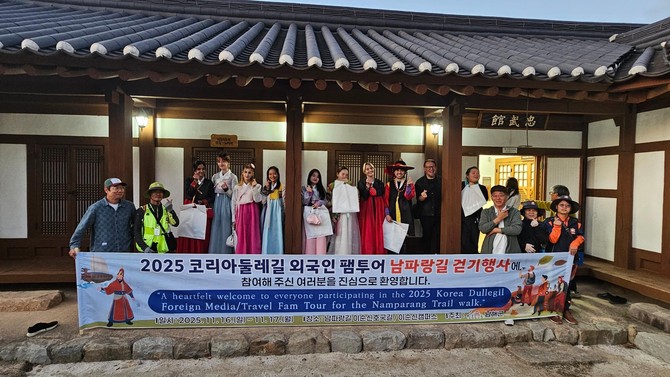 남해군이 외국인을 대상으로 '2025 코리아둘레길 외국인팸투어 남파랑길 걷기' 행사를 진행하고 이순신바다공원 이순신캠퍼스에서 기념촬영을 하고 있다. ⓒ 남해군