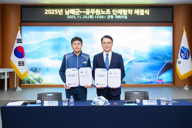 장충남 군수(오른쪽)와 강윤택 지부장이 군청 대회의실에서 '상생과 협력'을 위한 '2025년 단체협약'을 체결하고 기념촬영을 하고 있다. ⓒ 남해군